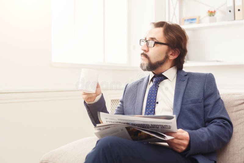 Pensive businessman reading newspaper in office royalty free stock photo Pensive businessman reading newspaper in office royalty free stock photo