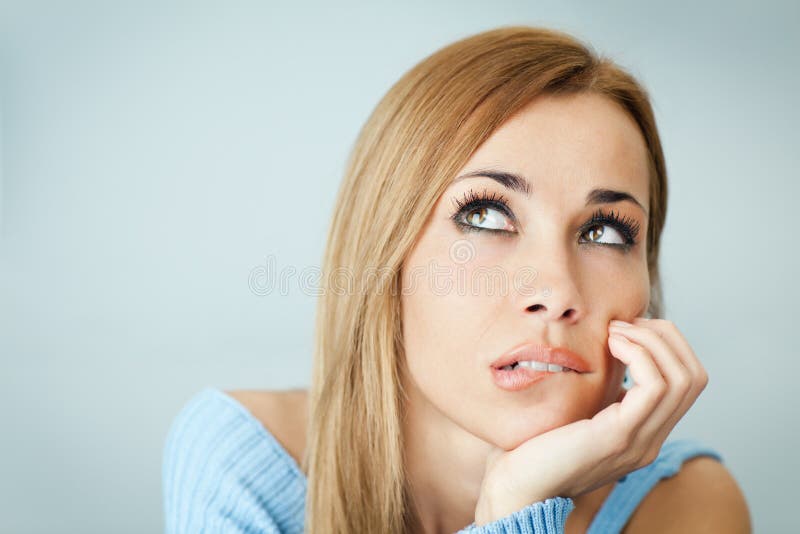 Pensive woman biting lips stock photography