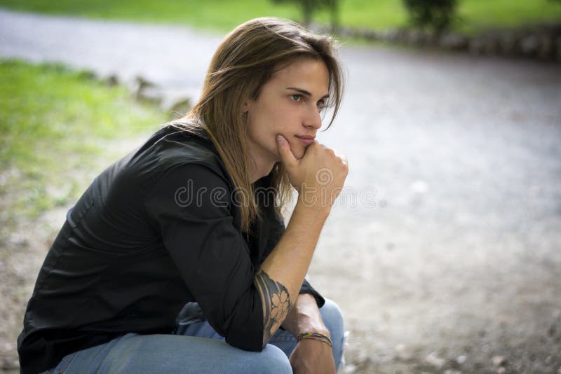 Pensée extérieure de jeune homme beau, triste ou inquiété photographie stock libre de droits Pensée extérieure de jeune homme beau, triste ou inquiété photographie stock libre de droits