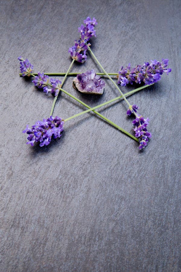 Pentagram - Witch, Wicca, Pagan symbol made of purple lavender flower spikes with amethyst cluster against gray / grey slate background