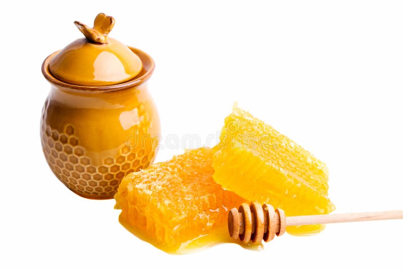 Pente de mel cortado dourado com vaso e colher de madeira imagem de stock royalty free