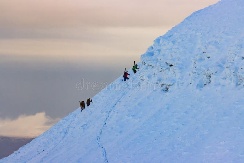 PEN-Y-FAN, WALES, UK - DECEMBER 06 2020: Skiers rest on the snow on a bright sunny day in the Brecon Beacons mountains. PEN-Y-FAN, WALES, UK - DECEMBER 06 2020: Skiers rest on the snow on a bright sunny day in the Brecon Beacons mountains.