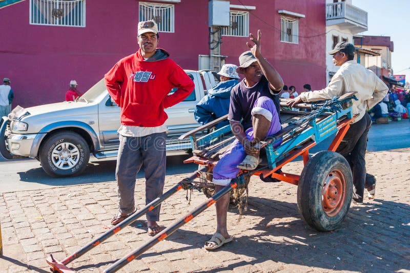 People in ANTANANARIVO, MADAGASCAR. ANTANANARIVO, MADAGASCAR - JUNE 27, 2011: Unidentified Madagascar man sitting on the carriage in the street. People in royalty free stock photography People in ANTANANARIVO, MADAGASCAR. ANTANANARIVO, MADAGASCAR - JUNE 27, 2011: Unidentified Madagascar man sitting on the carriage in the street. People in royalty free stock photography