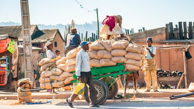 People in ANTANANARIVO, MADAGASCAR. ANTANANARIVO, MADAGASCAR - JUNE 27, 2011: Unidentified Madagascar woman stays over the bags on a carriage. People in royalty free stock image People in ANTANANARIVO, MADAGASCAR. ANTANANARIVO, MADAGASCAR - JUNE 27, 2011: Unidentified Madagascar woman stays over the bags on a carriage. People in royalty free stock image