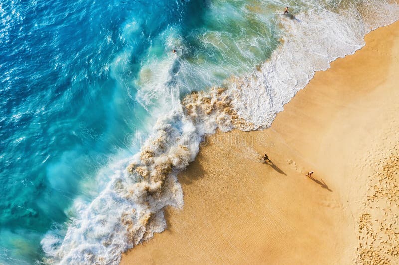 People on the beach on Bali, Indonesia. Vacation and adventure. Beach and large waves. Top view from drone at beach, azure sea and