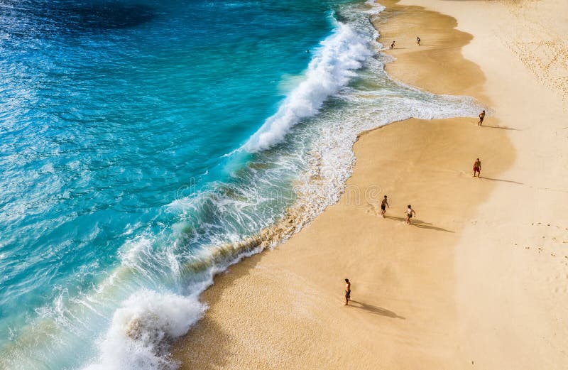 People on the beach on Bali, Indonesia. Vacation and adventure. Beach and large waves. Top view from drone at beach, azure sea and