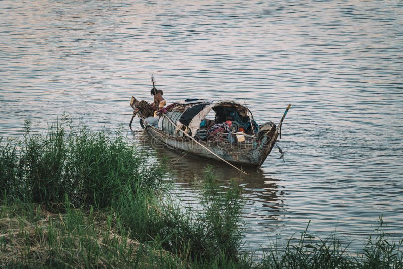 People in Boat on River Floating Village in Cambodia Asia. poor Cambodian family lives in boat on the water. Poverty in Southeast stock photo People in Boat on River Floating Village in Cambodia Asia. poor Cambodian family lives in boat on the water. Poverty in Southeast stock photo