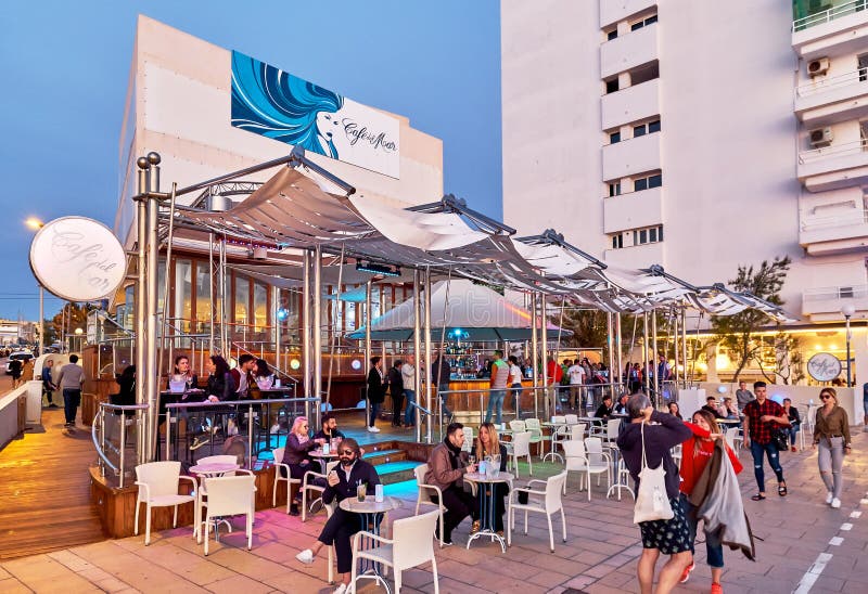 Ibiza Island, Spain - May 1, 2018: People at Cafe Del Mar cafe at sunset. This place is famous for views to the sunsets and lounge music. Ibiza, Balearic Islands. Spain. Ibiza Island, Spain - May 1, 2018: People at Cafe Del Mar cafe at sunset. This place is famous for views to the sunsets and lounge music. Ibiza, Balearic Islands. Spain