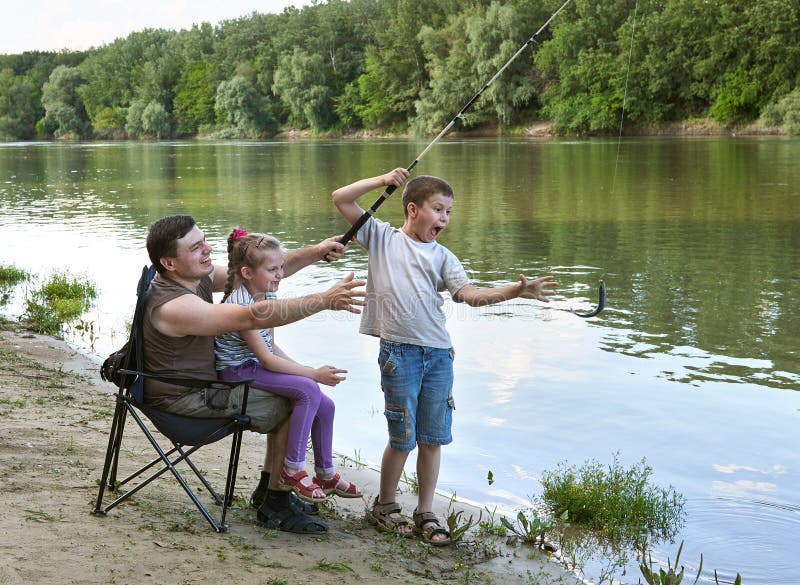 People camping and fishing, family active in nature, fish caught on bait, river and forest, summer season