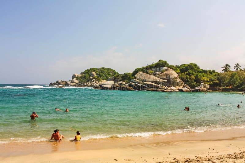 People in Caribbean beach with tropical forest in Tayrona National Park, Colombia. Tayrona National Park is located in the