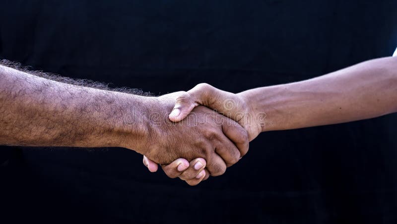 People concepts. Two men shaking hands isolated on black backgrounds