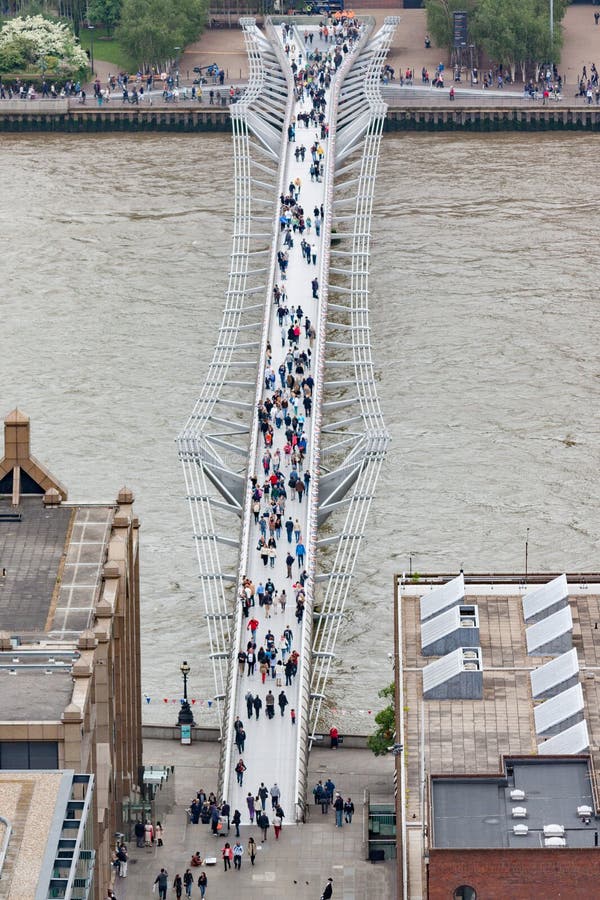 People Crossing the Millennium Bridge in London. The Millennium Bridge was completed in 2000, and reopened in 2002 after modifications to fix excessive swaying stock image People Crossing the Millennium Bridge in London. The Millennium Bridge was completed in 2000, and reopened in 2002 after modifications to fix excessive swaying stock image