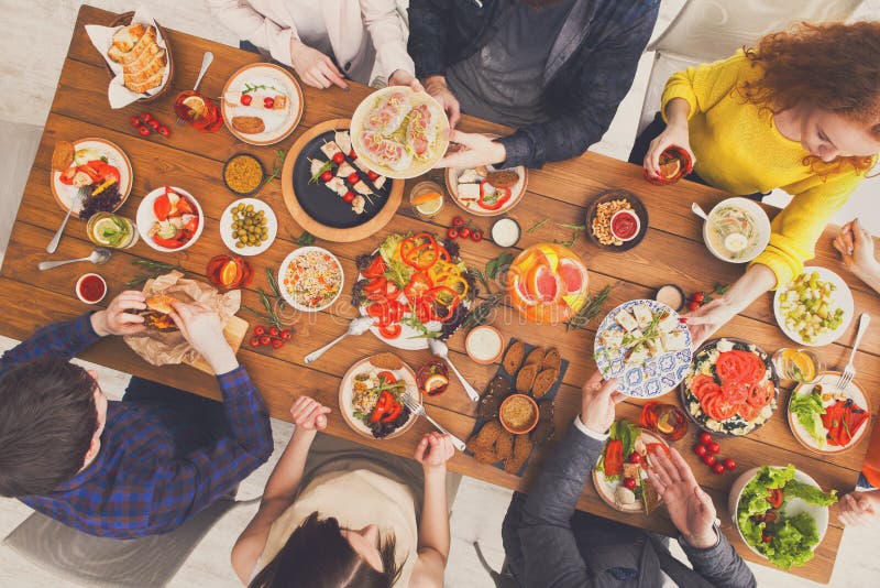 People Eat and Share Healthy Meals at Served Table Dinner Party Stock