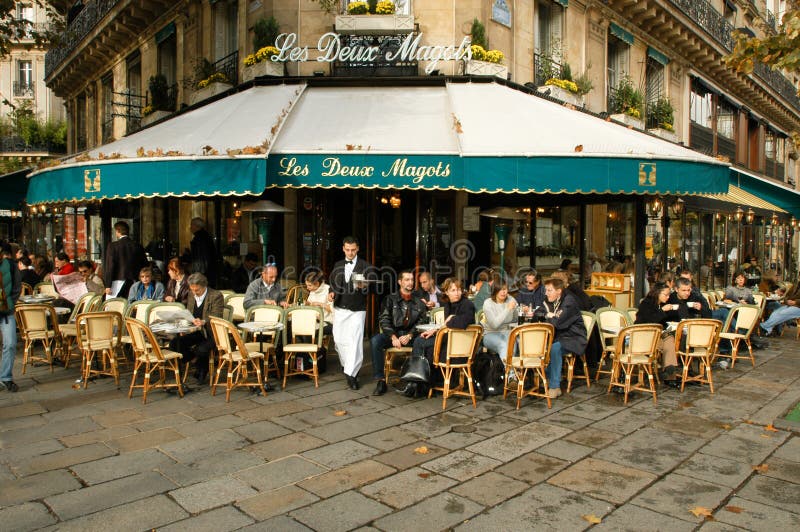 People eating and drinking in a street restaurant of Paris