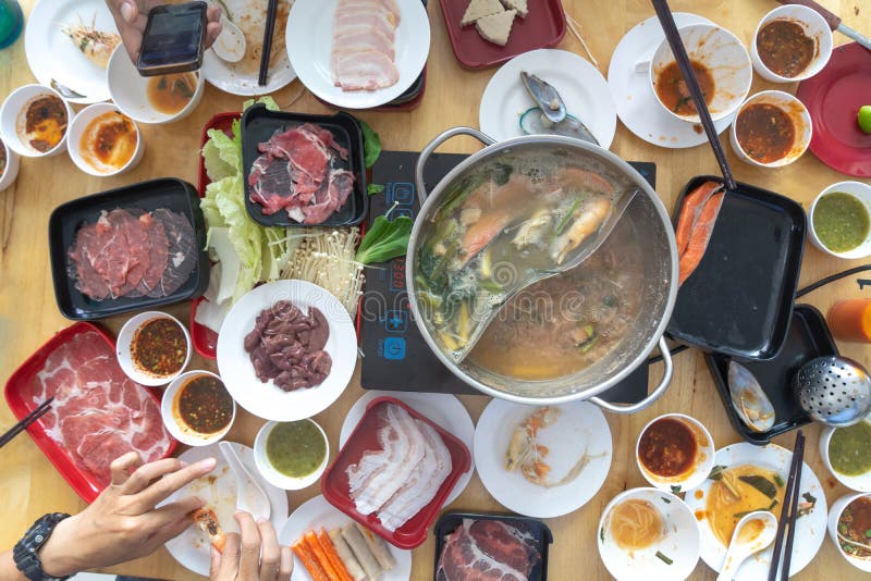 People enjoy eating Shabu Sukiyaki, Japanese food together top view stock image People enjoy eating Shabu Sukiyaki, Japanese food together top view stock image