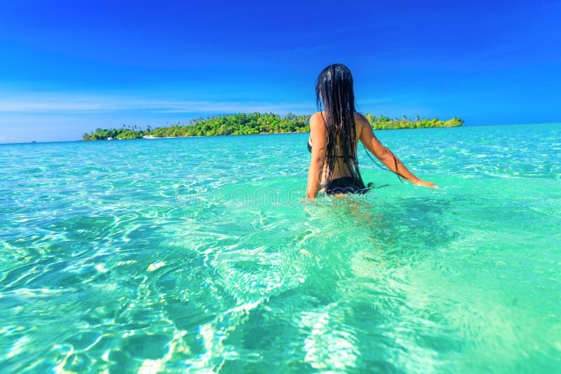 People enjoy vacation on tropical sandy beach on background sea water and blue sky