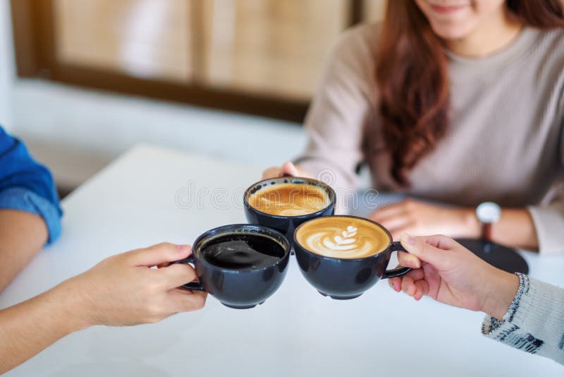 People enjoyed drinking and clinking coffee cups together on the table in cafe royalty free stock photo