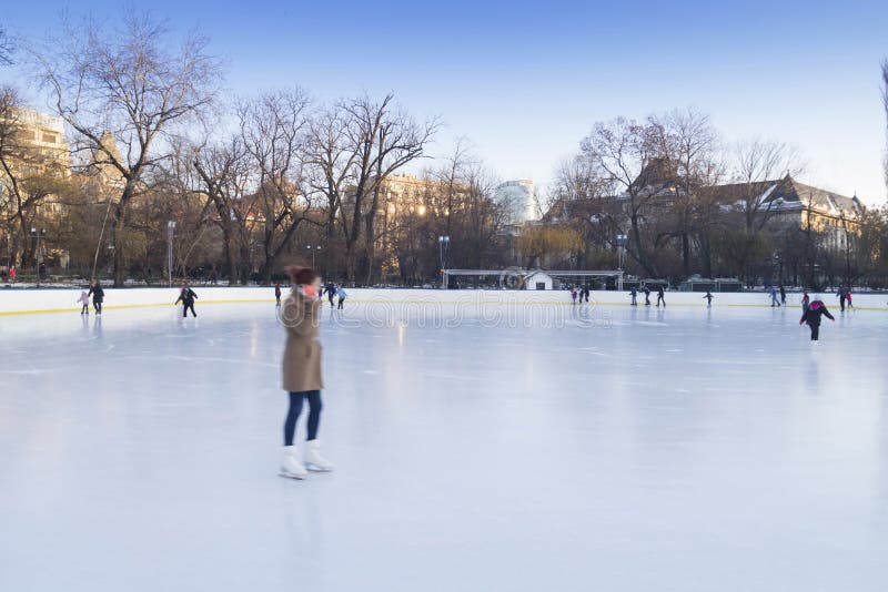People enjoying ice skating rink stock photo