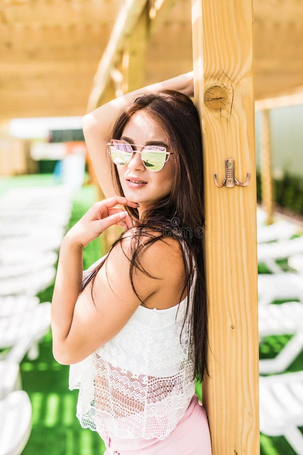 People, fashion, summer and beach concept - happy young woman in summer clothes over swimming pool at beach resort stock photos People, fashion, summer and beach concept - happy young woman in summer clothes over swimming pool at beach resort stock photos