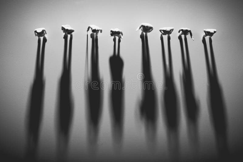 People figures standing in a row, casting shadows. royalty free stock images
