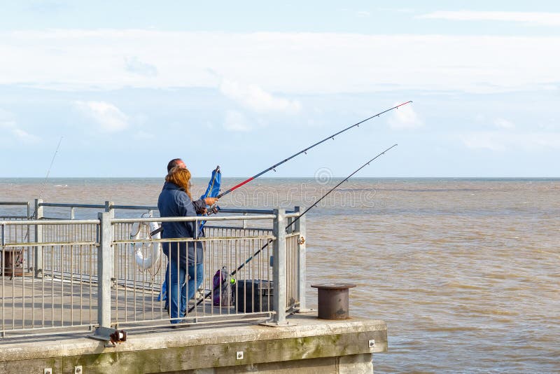 People fishing with fishing rods on Southwold Pier in the UK royalty free stock photos People fishing with fishing rods on Southwold Pier in the UK royalty free stock photos