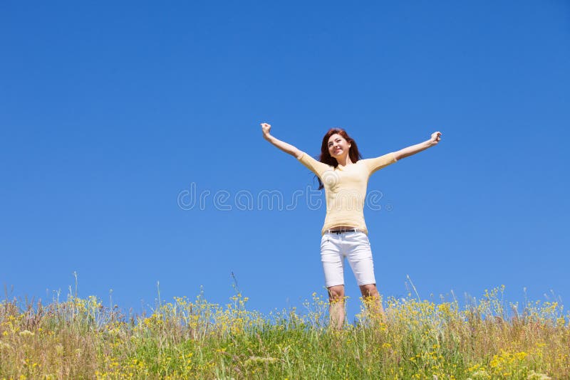 People freedom success concept. Happy woman dreams to fly on winds. Landscape of grass and flower summer field on sunny day.