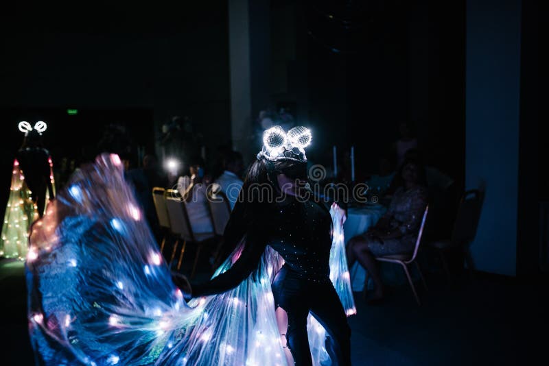 People in glowing costumes dancing in the dark stock photo People in glowing costumes dancing in the dark stock photo
