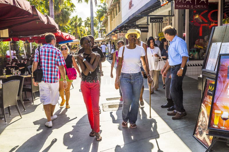 People go shopping in the afternoon sun in Lincoln Road