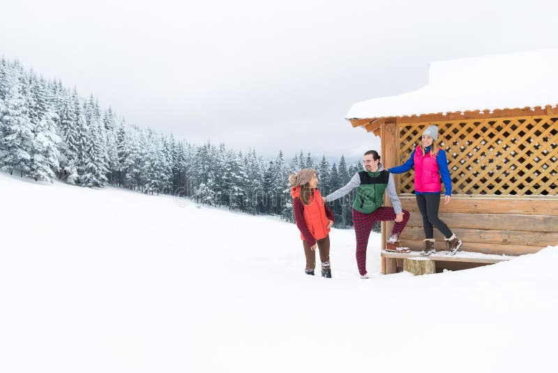 People Group Near Wooden Country House Winter Snow Resort Cottage. Christmas, caucasian.