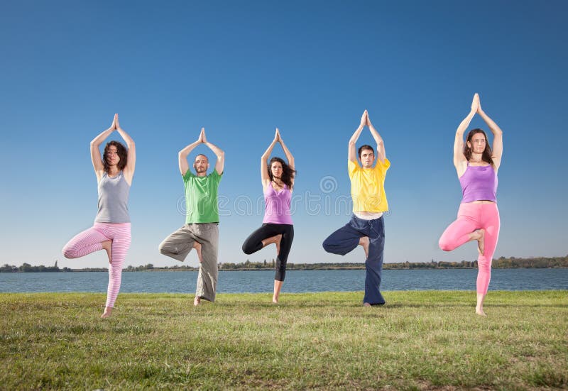 People in group practice Yoga asana on lakeside.