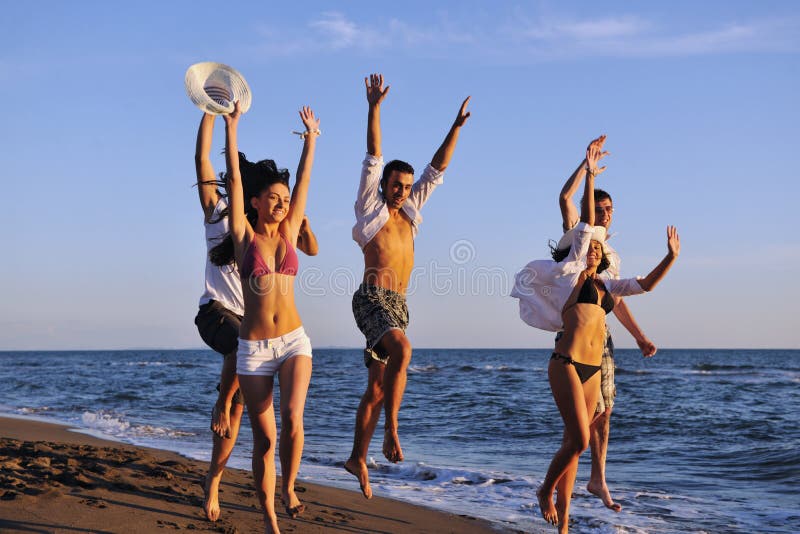 People group running on the beach. Friendship, friends.