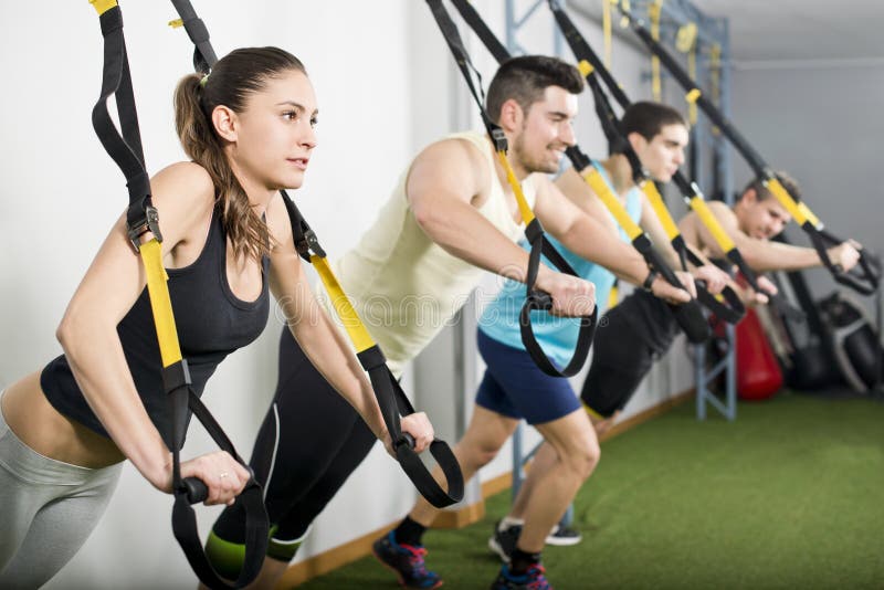 People at gym doing trx exercises stock images People at gym doing trx exercises stock images