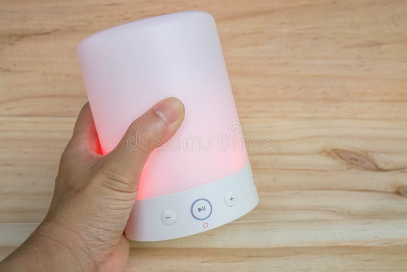 People hand hold glow pink modern wireless speaker with left hand for music player stock photo
