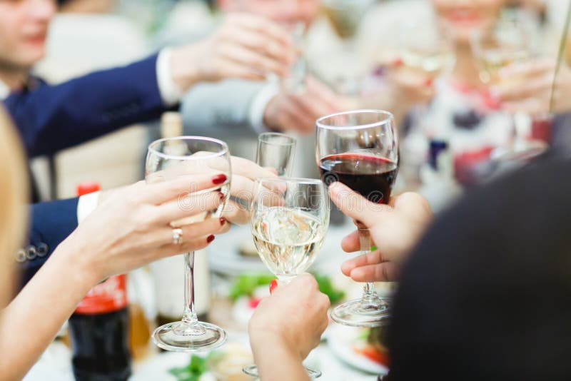 People hold in hands glasses with white and red wine royalty free stock photography