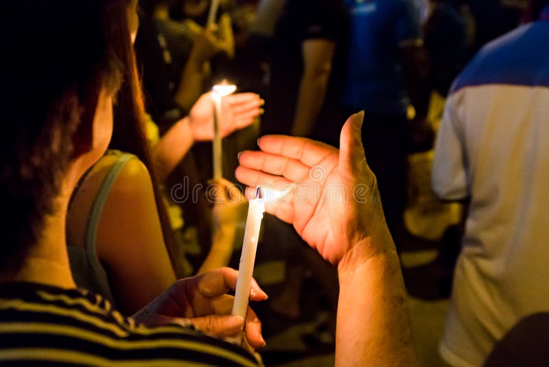 Gruppo di persone con in mano la candela di veglia nel buio in cerca di speranza, di culto, di preghiera.