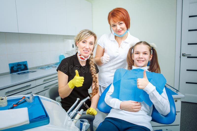 People, medicine, stomatology and health care concept - happy female dentist checking patient teen girl teeth up at royalty free stock photos People, medicine, stomatology and health care concept - happy female dentist checking patient teen girl teeth up at royalty free stock photos