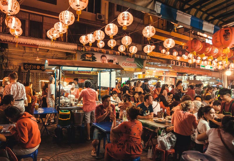 People meeting, talking and eating asian food at street restaurant of China Town in night