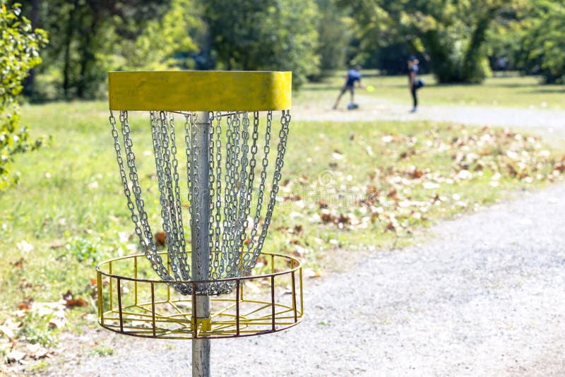 People Playing Flying Disc Golf Sport Game in the Park Stock Photo