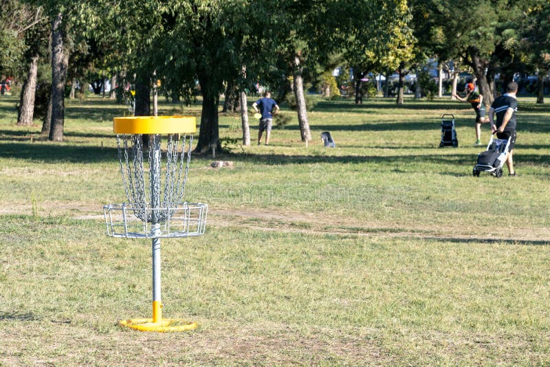 People Playing Flying Disc Golf Sport Game in the Park Stock Image