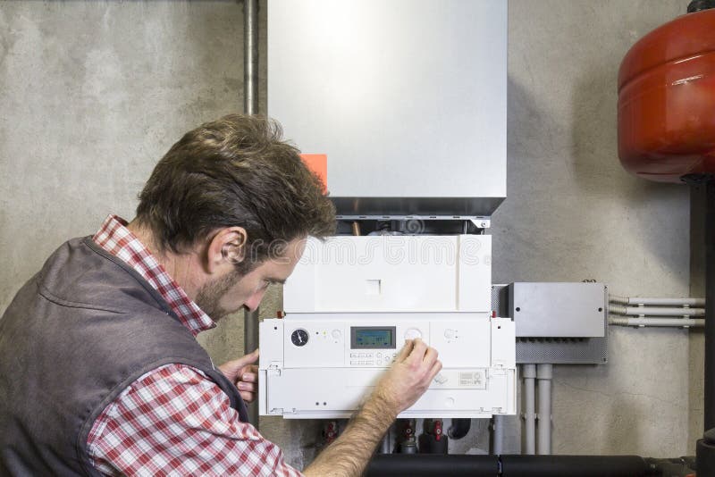 Plumber repairing a condensing boiler