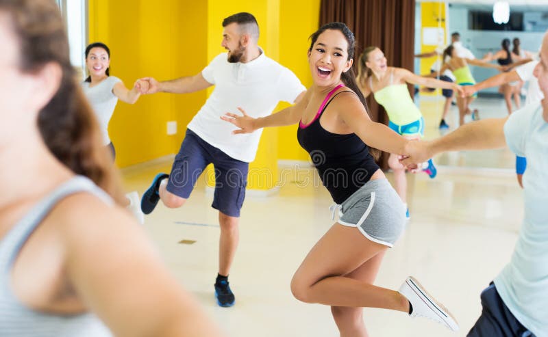 People practicing vigorous lindy hop. Smiling people practicing vigorous lindy hop movements in dance class