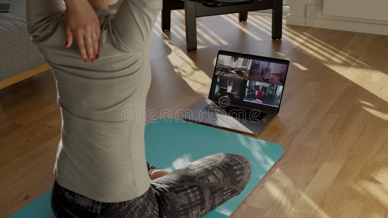 People practicing yoga with trainer via video conference
