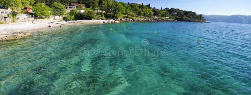 People rest on rocky Adriatic coastline in surrounding of Glavotok monastery on May 2, 2017. The