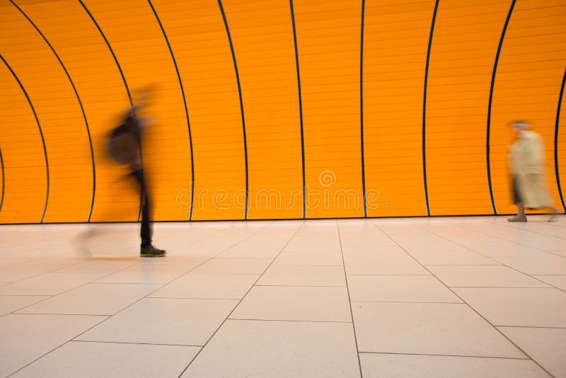 People rushing through a subway corridor