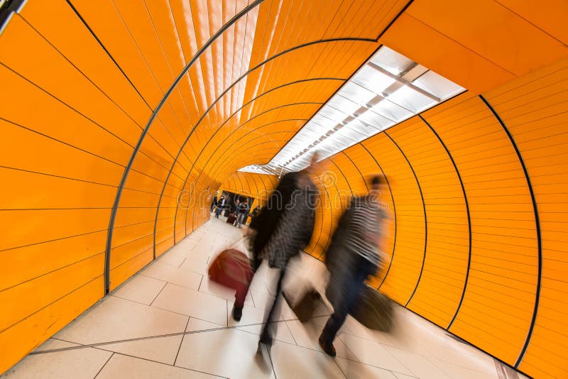 People rushing through a subway corridor