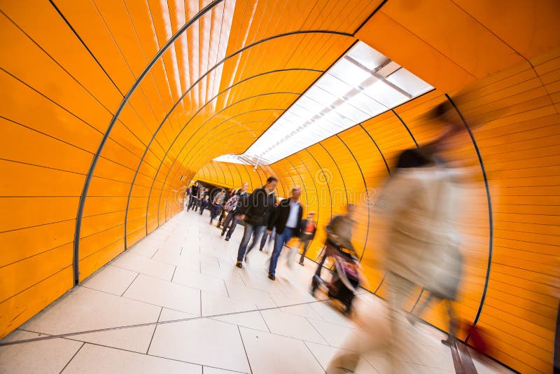 People rushing through a subway corridor