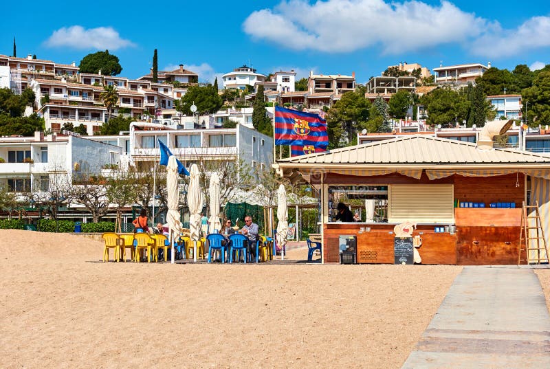 Tossa de Mar, Spain - April 7, 2016: People sitting in a beach cafe of Tossa del Mar, Costa Brava. Catalonia, Spain