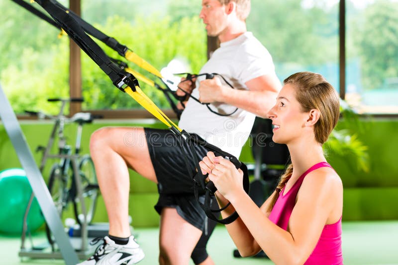 People in sport gym on suspension trainer stock photos