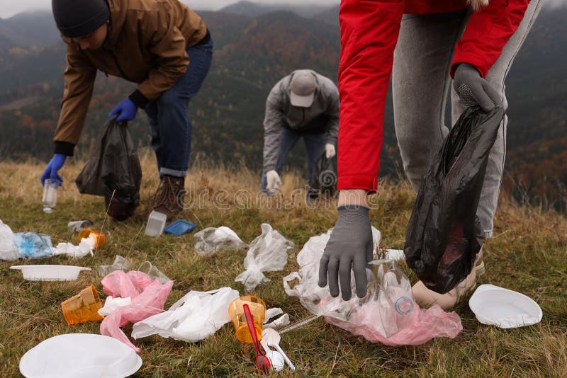 People with Trash Bags Collecting Garbage in Nature, Closeup Stock