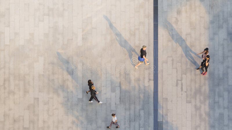 people walk on across the pedestrian concrete landscape with black silhouette shadow on ground (top aerial view) stock photography people walk on across the pedestrian concrete landscape with black silhouette shadow on ground (top aerial view) stock photography